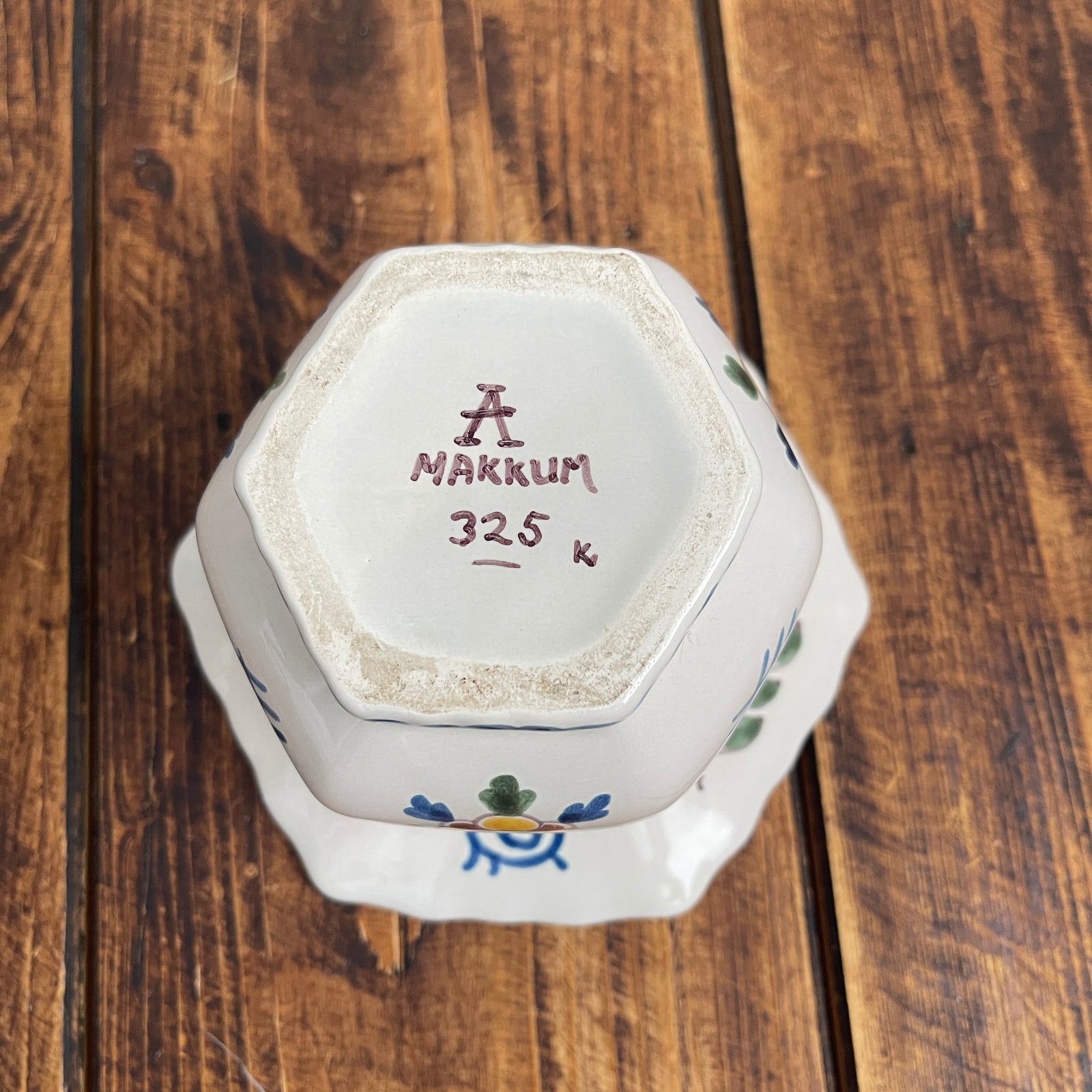 Hexagonal ceramic container with 'MAKKUM' branding on a wooden surface
