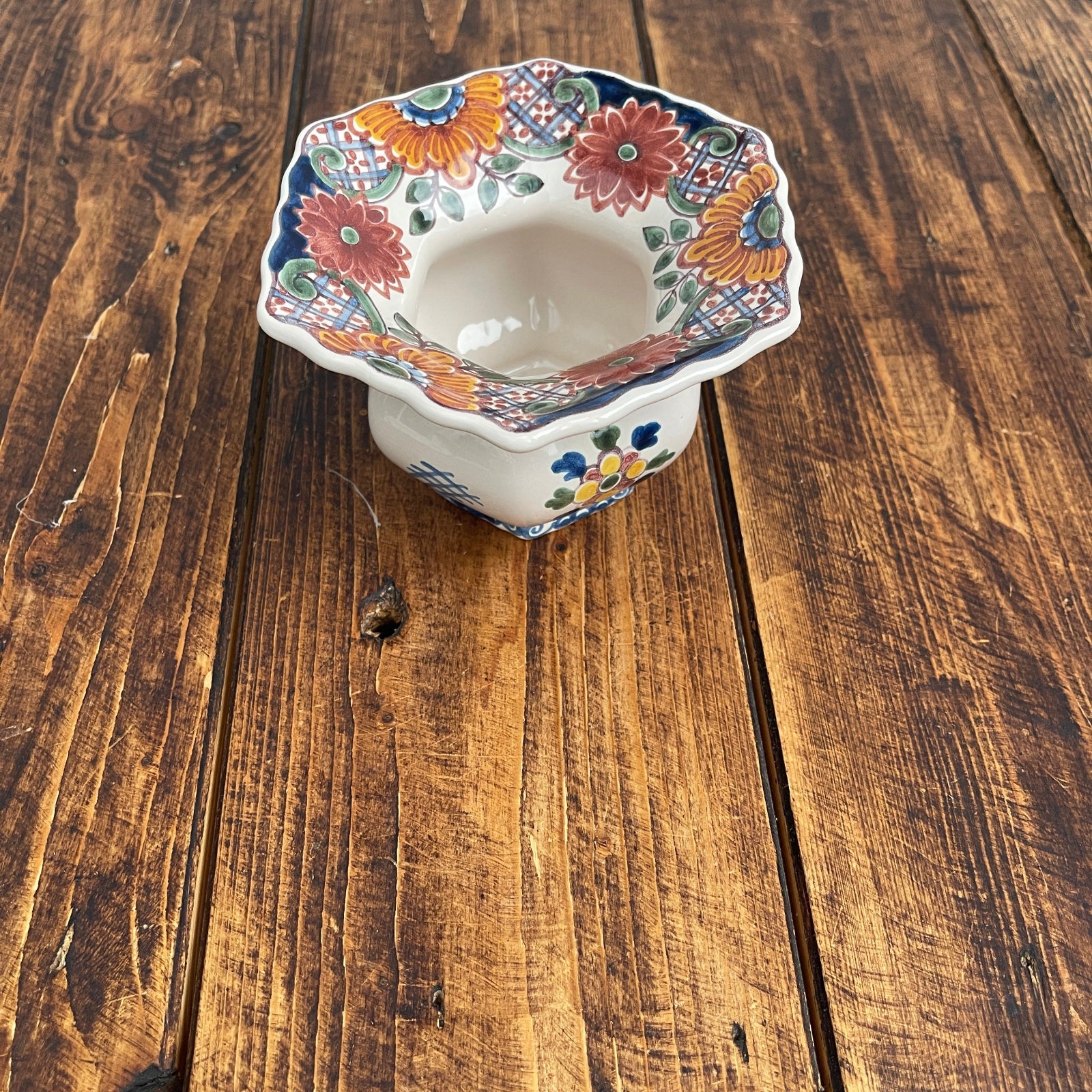 Decorative ceramic bowl with floral patterns on a wooden surface