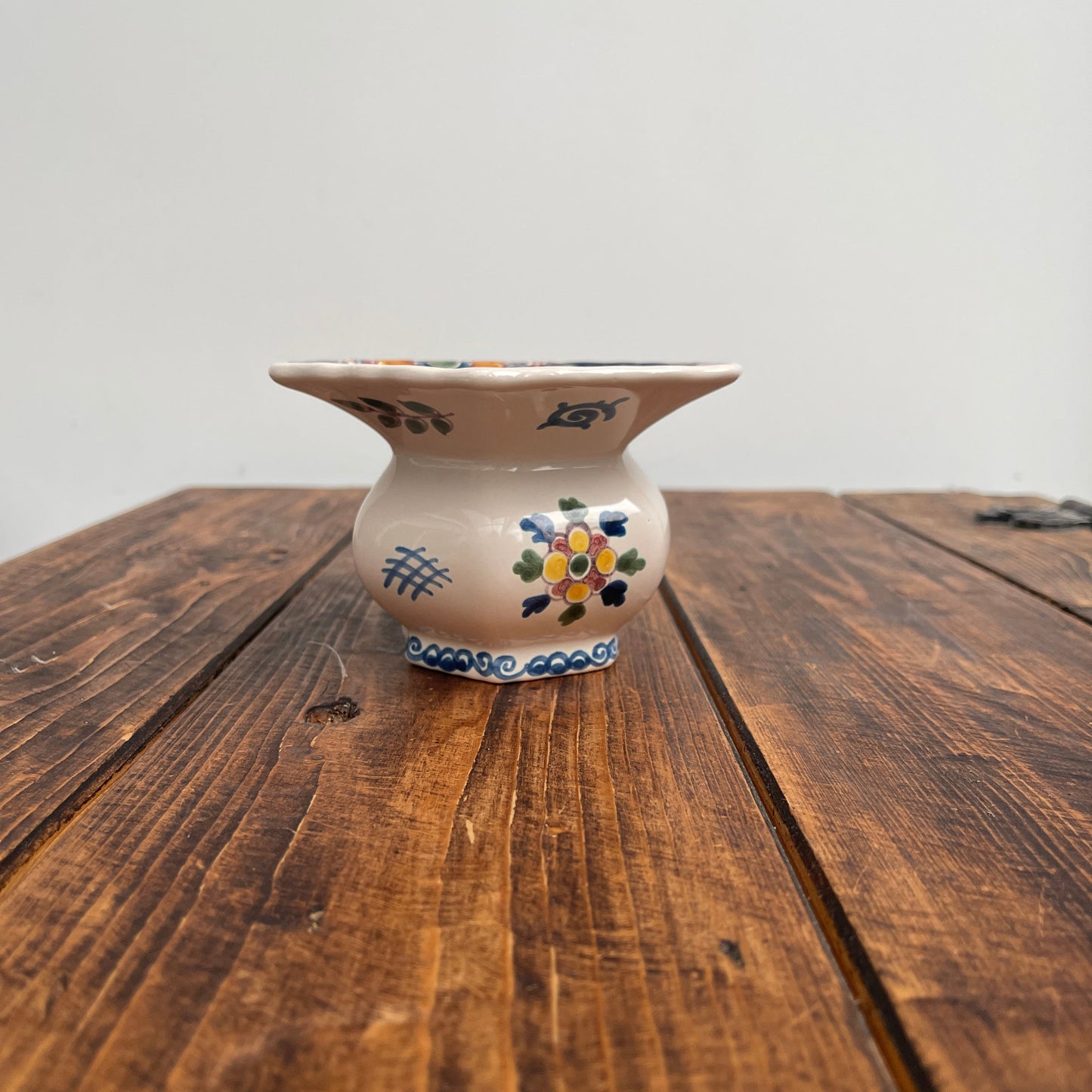 Decorative ceramic vase with floral patterns on a wooden surface