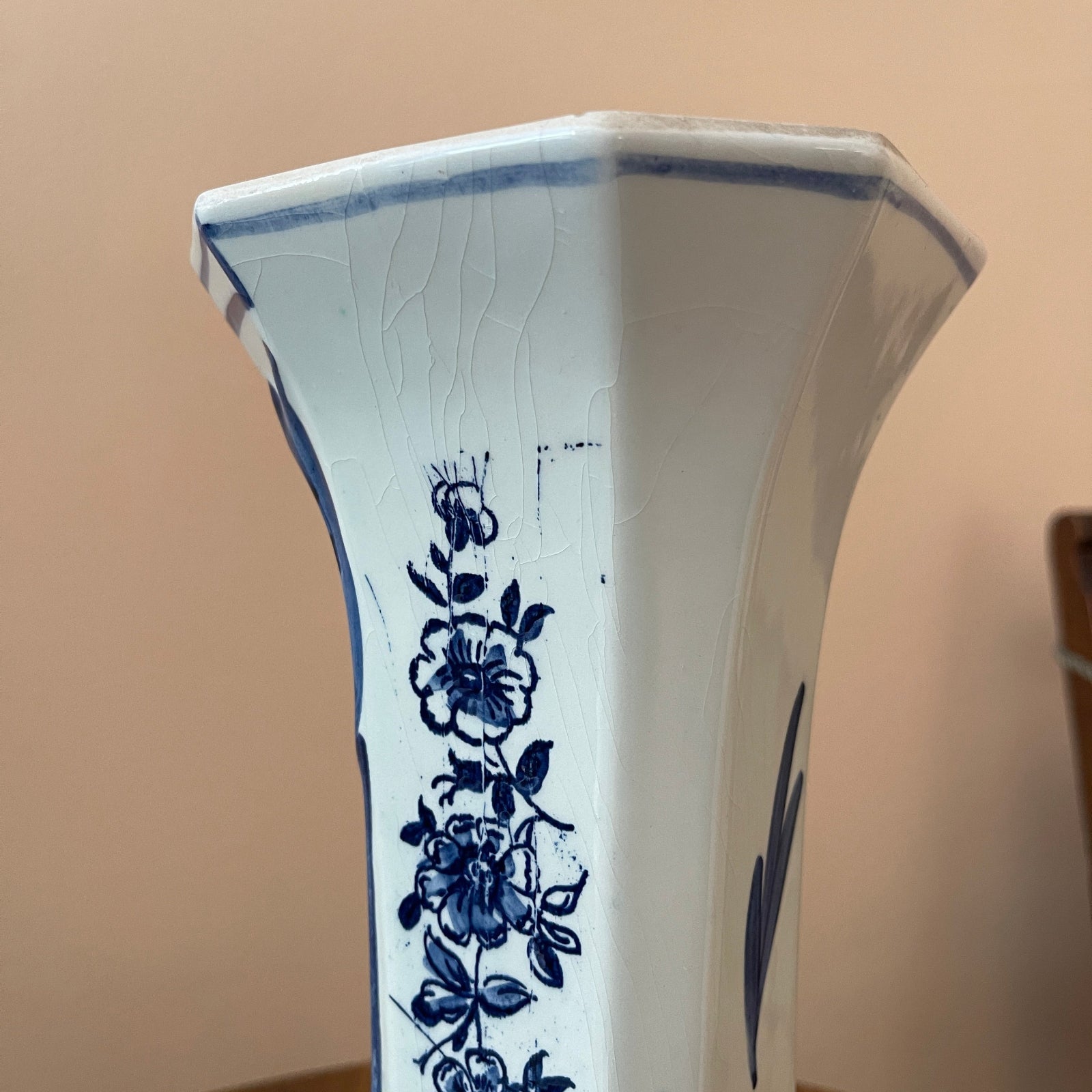 White ceramic vase with blue floral patterns on a beige background