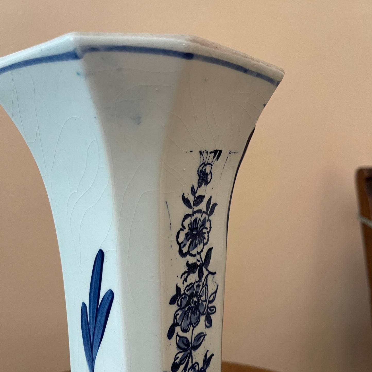 Ceramic vase with blue floral patterns on a beige background