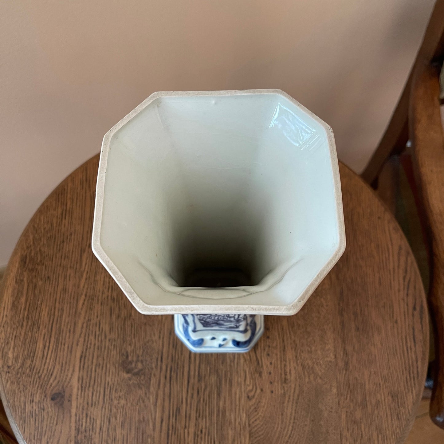 White octagonal vase on a wooden surface with a neutral background