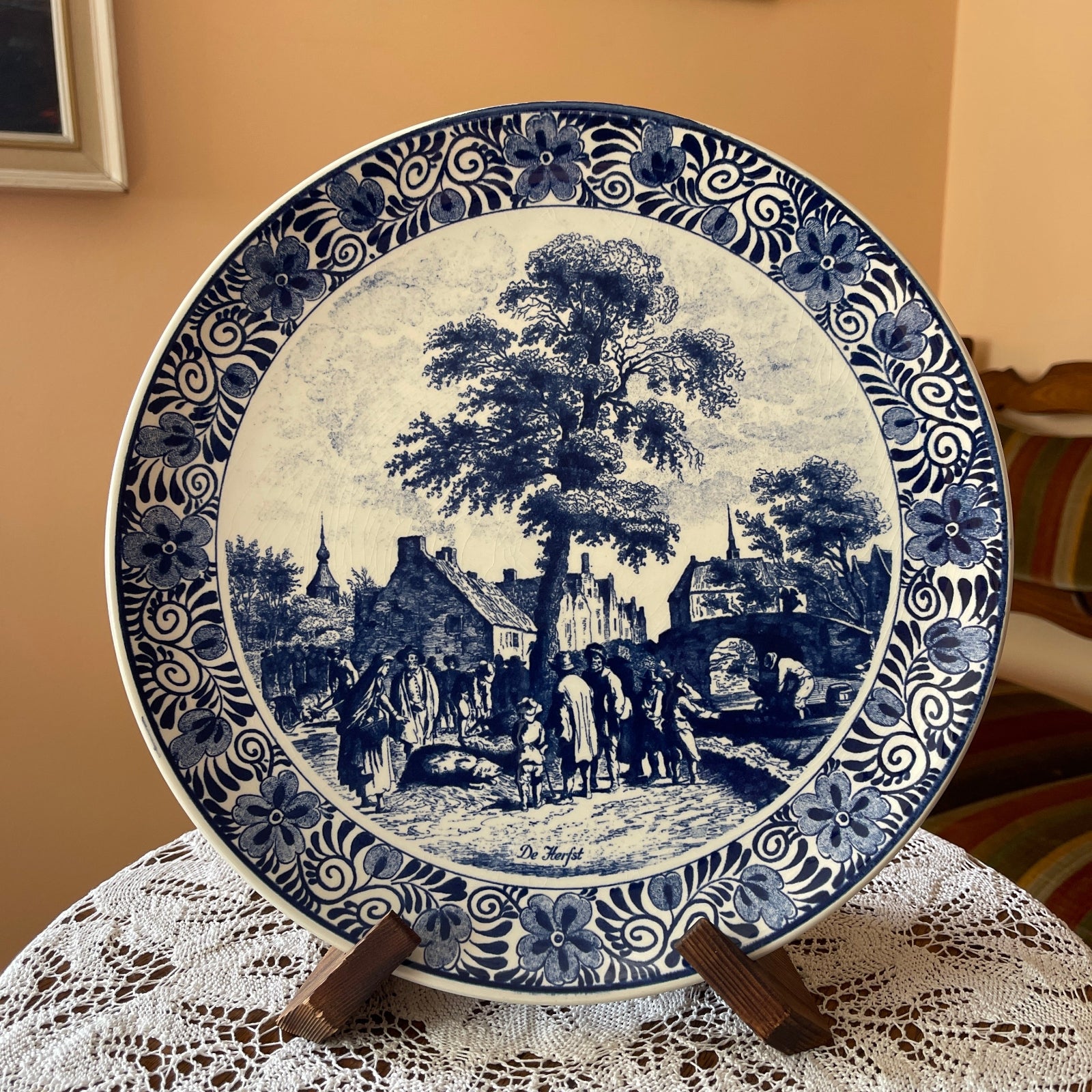 Blue and white ceramic plate with a scenic design on a lace tablecloth.