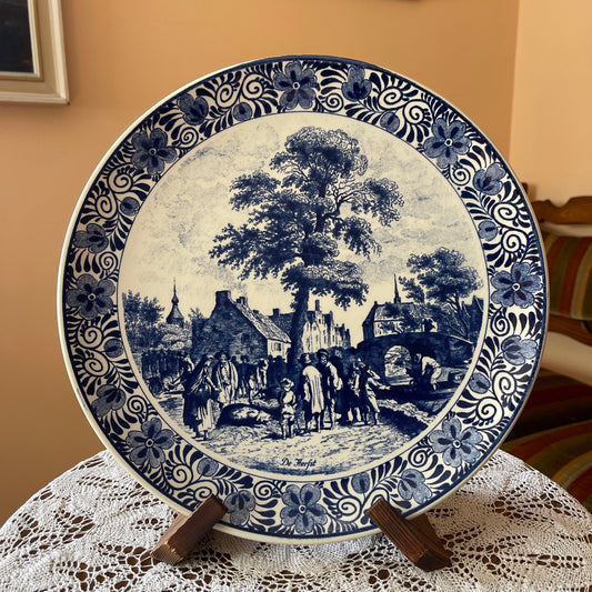 Blue and white ceramic plate with a scenic design on a lace tablecloth.