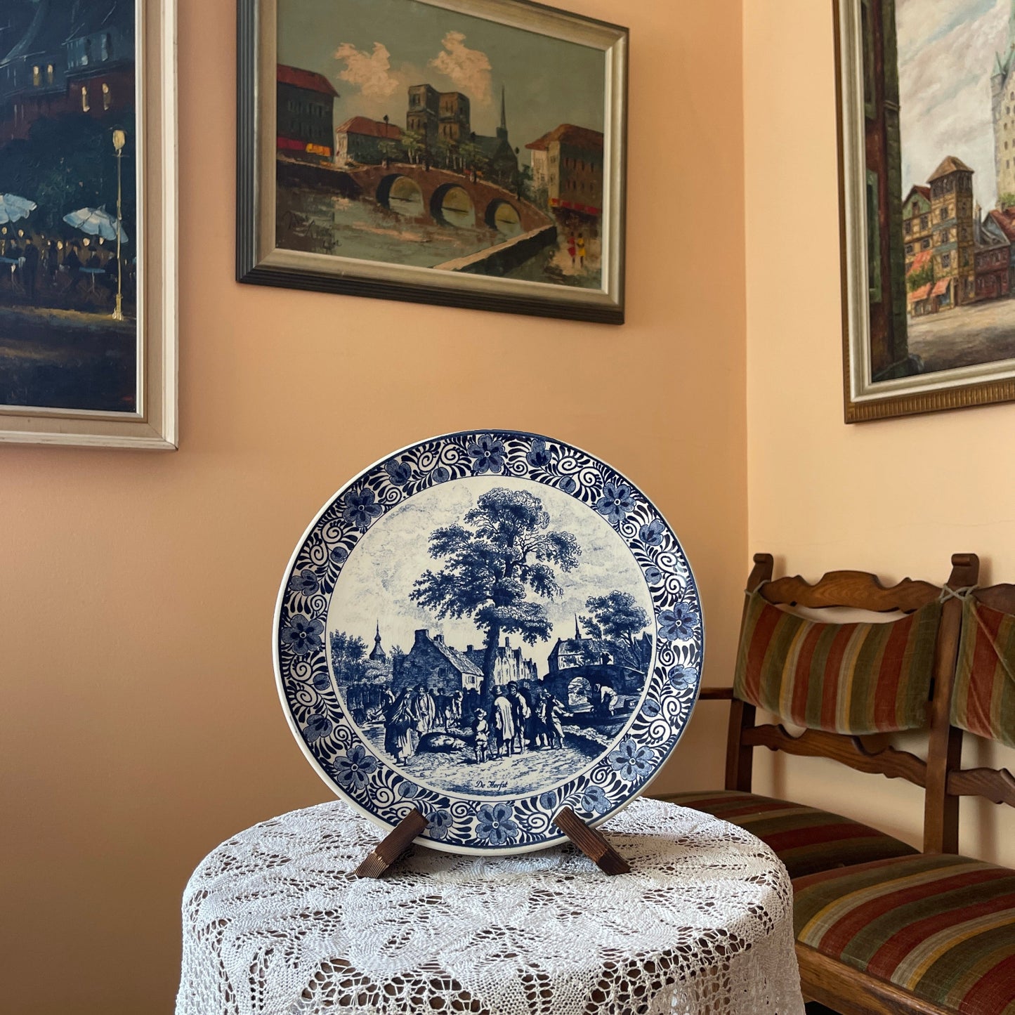 Blue and white decorative plate on a stand with paintings on the wall