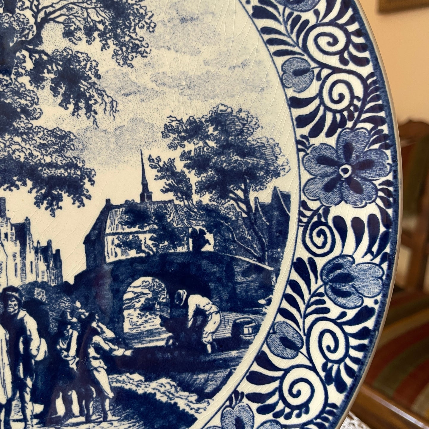 Decorative plate with blue and white floral design and black and white landscape scene.