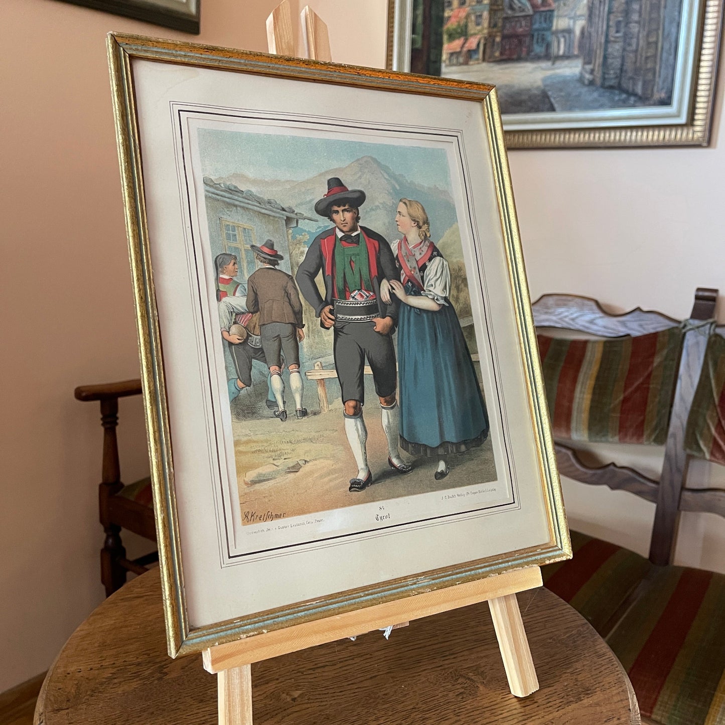 Framed print of a historical scene with people on a wooden easel.