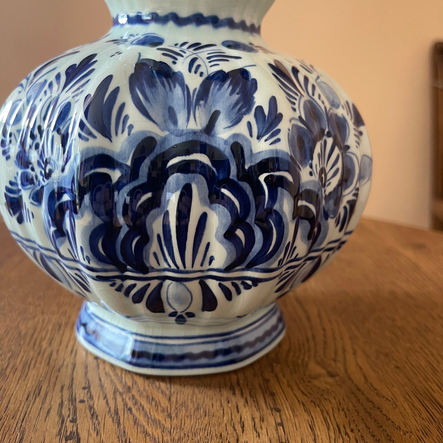 Blue and white ceramic vase with floral patterns on a wooden surface