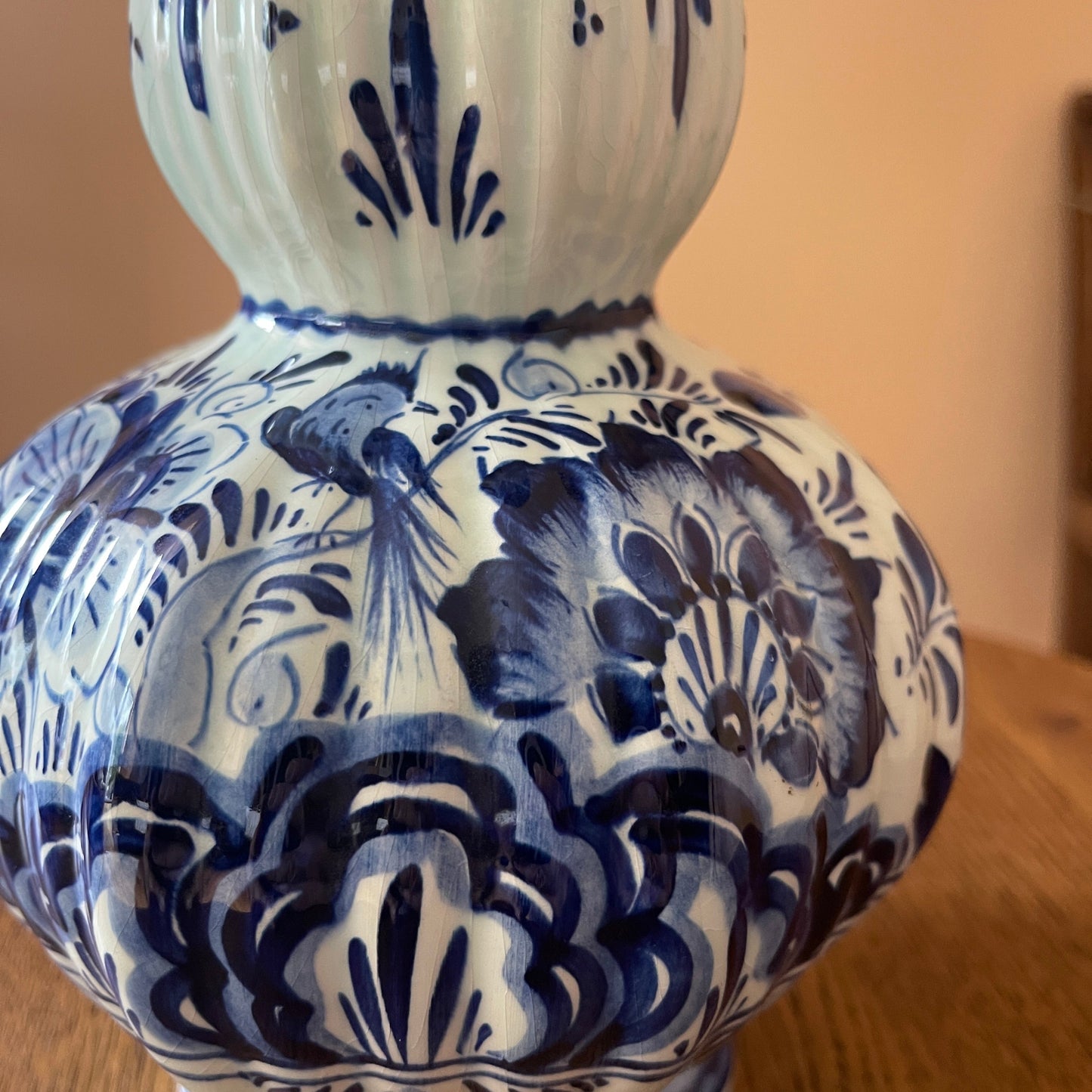 Blue and white ceramic vase with intricate patterns on a wooden surface.
