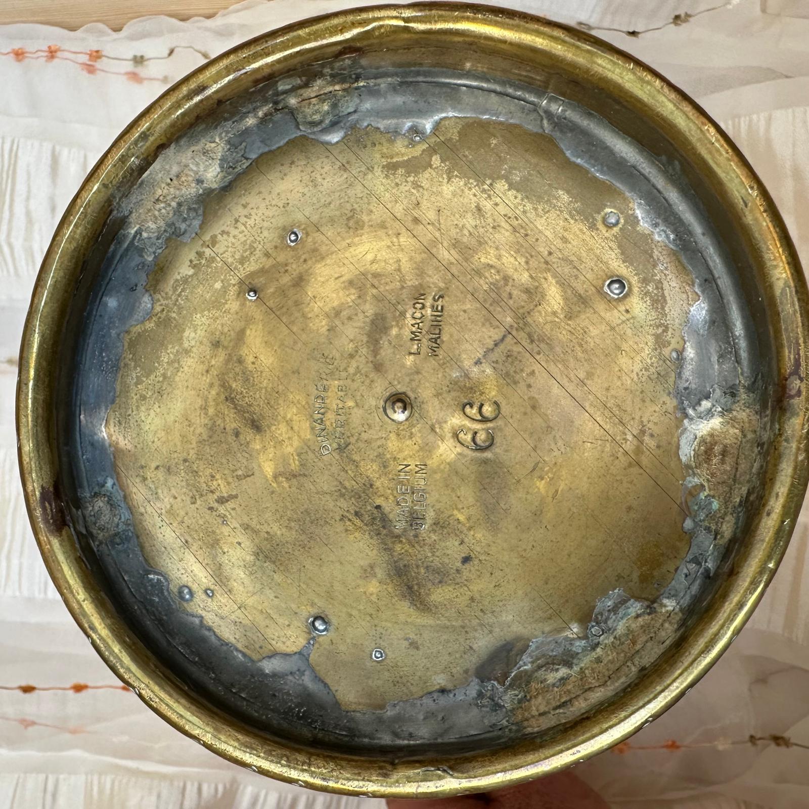 Worn brass lid with visible signs of aging on a textured surface