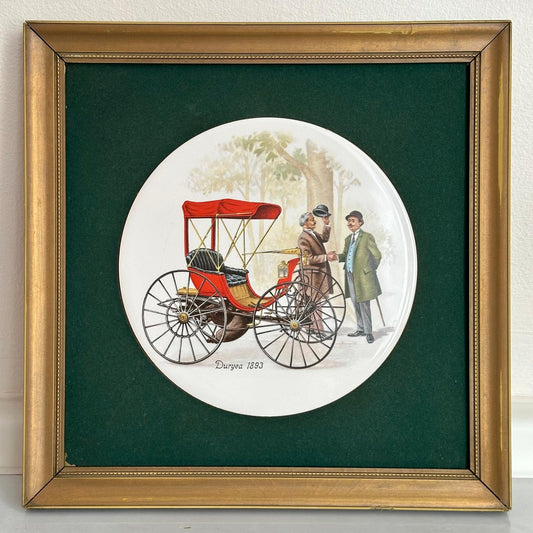 Framed artwork of a vintage carriage with two people on a green background