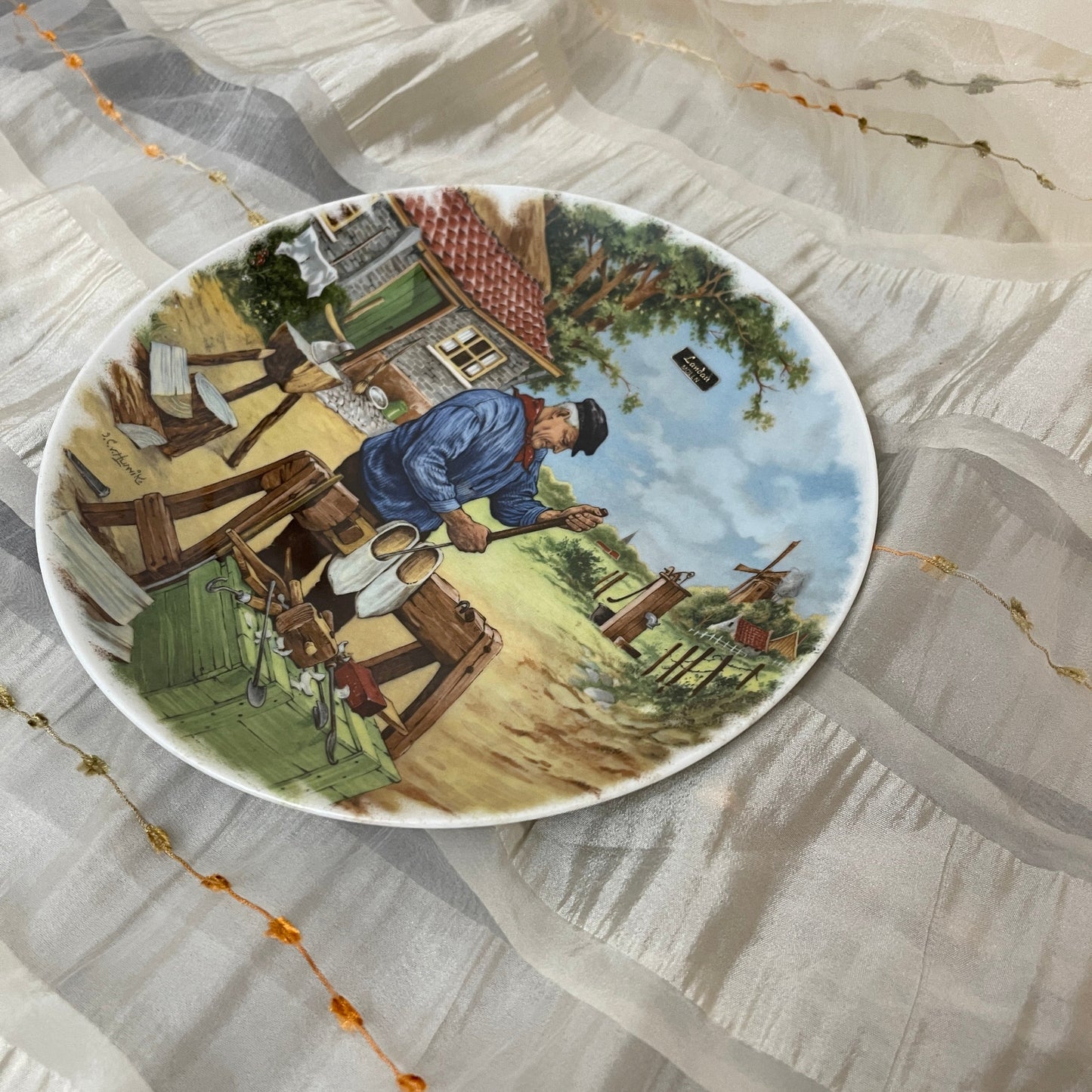Decorative plate with a rural scene on a textured surface