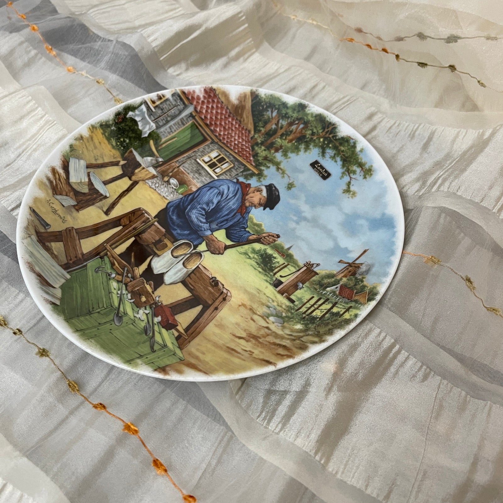 Decorative plate with a rural scene on a textured surface