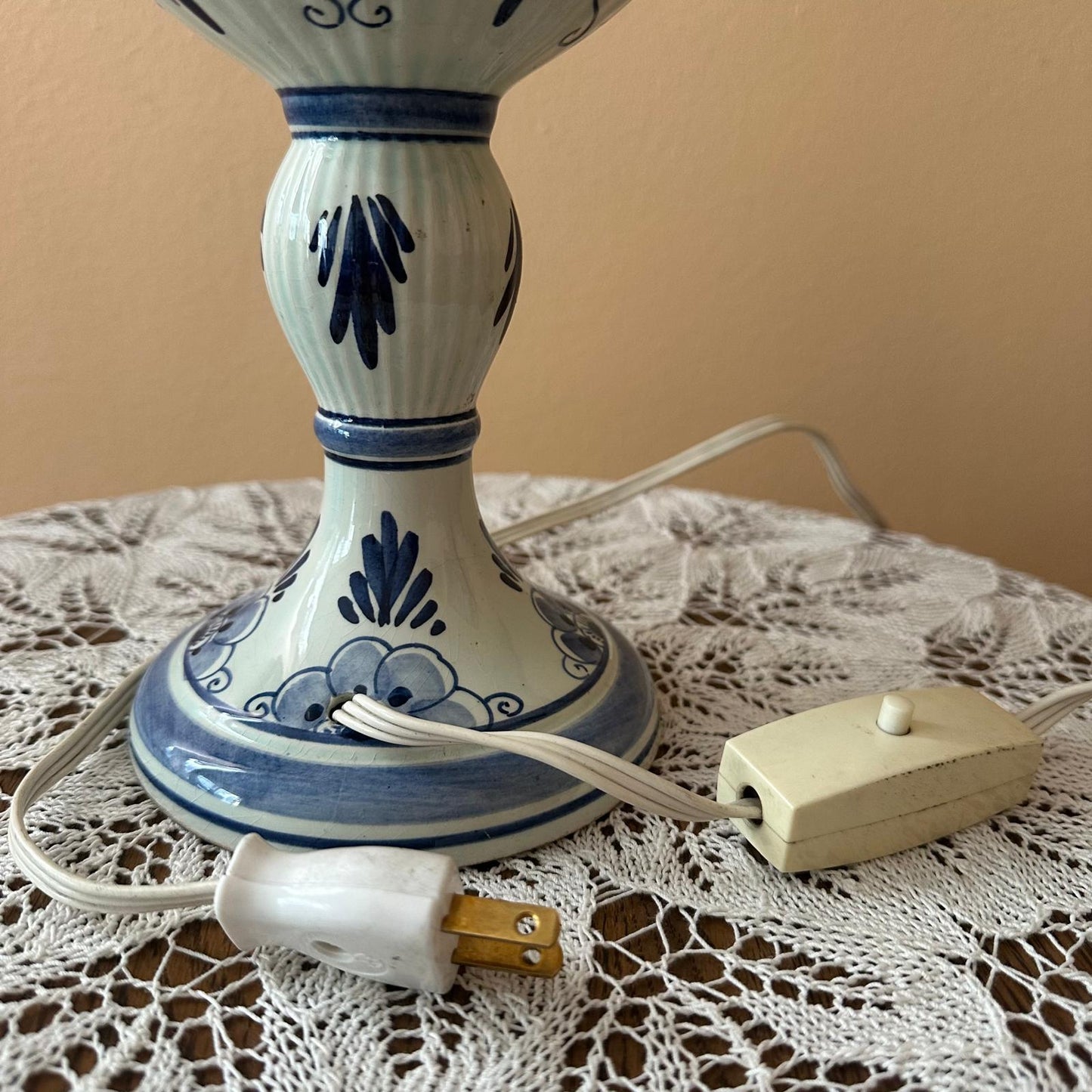 Ceramic lamp with blue decorative patterns on a lace tablecloth