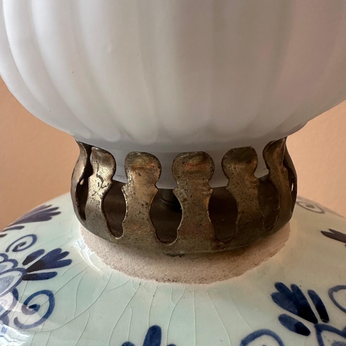 Close-up of a ceramic lamp with a decorative base on a plain background