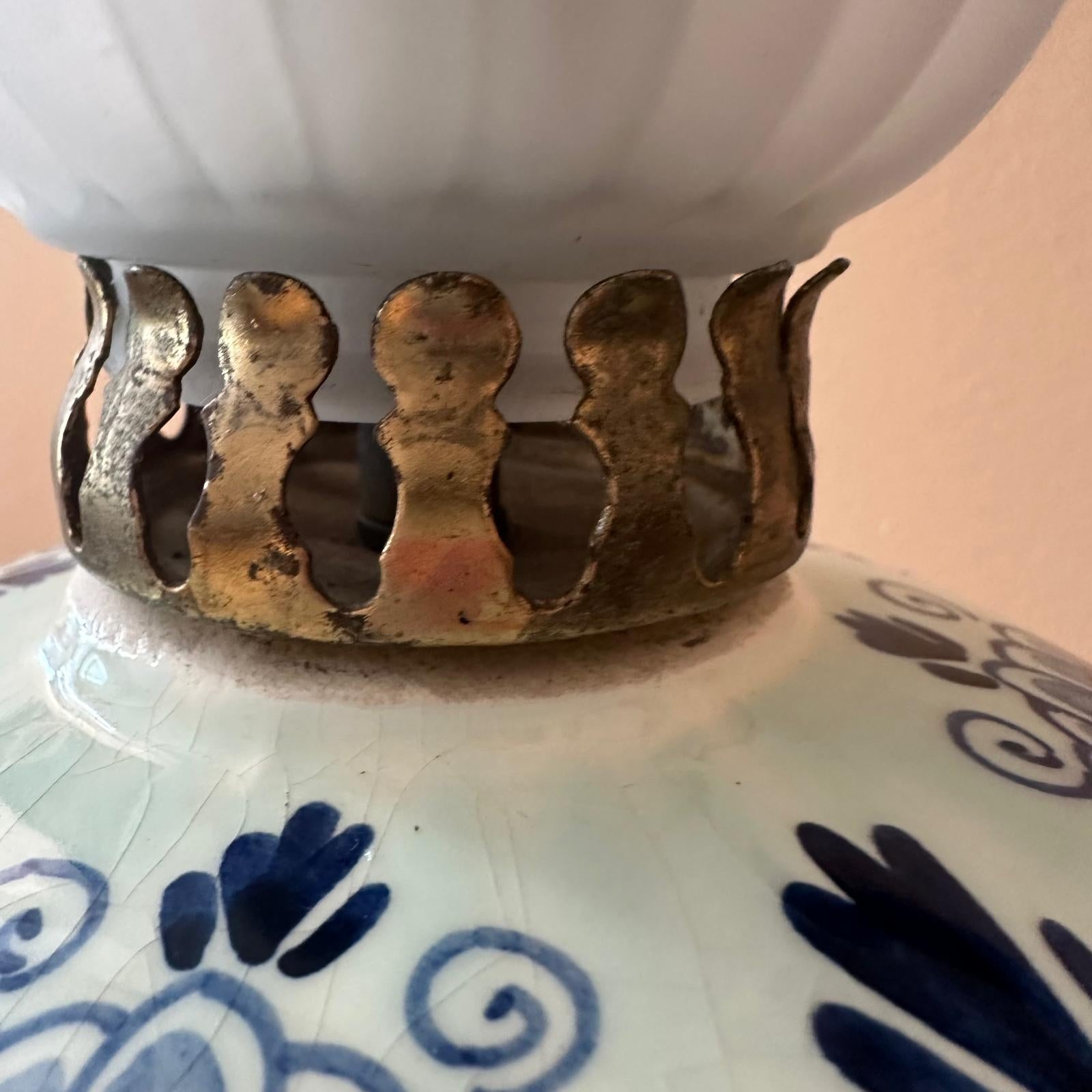Close-up of a decorative ceramic item with blue patterns and a metallic base.