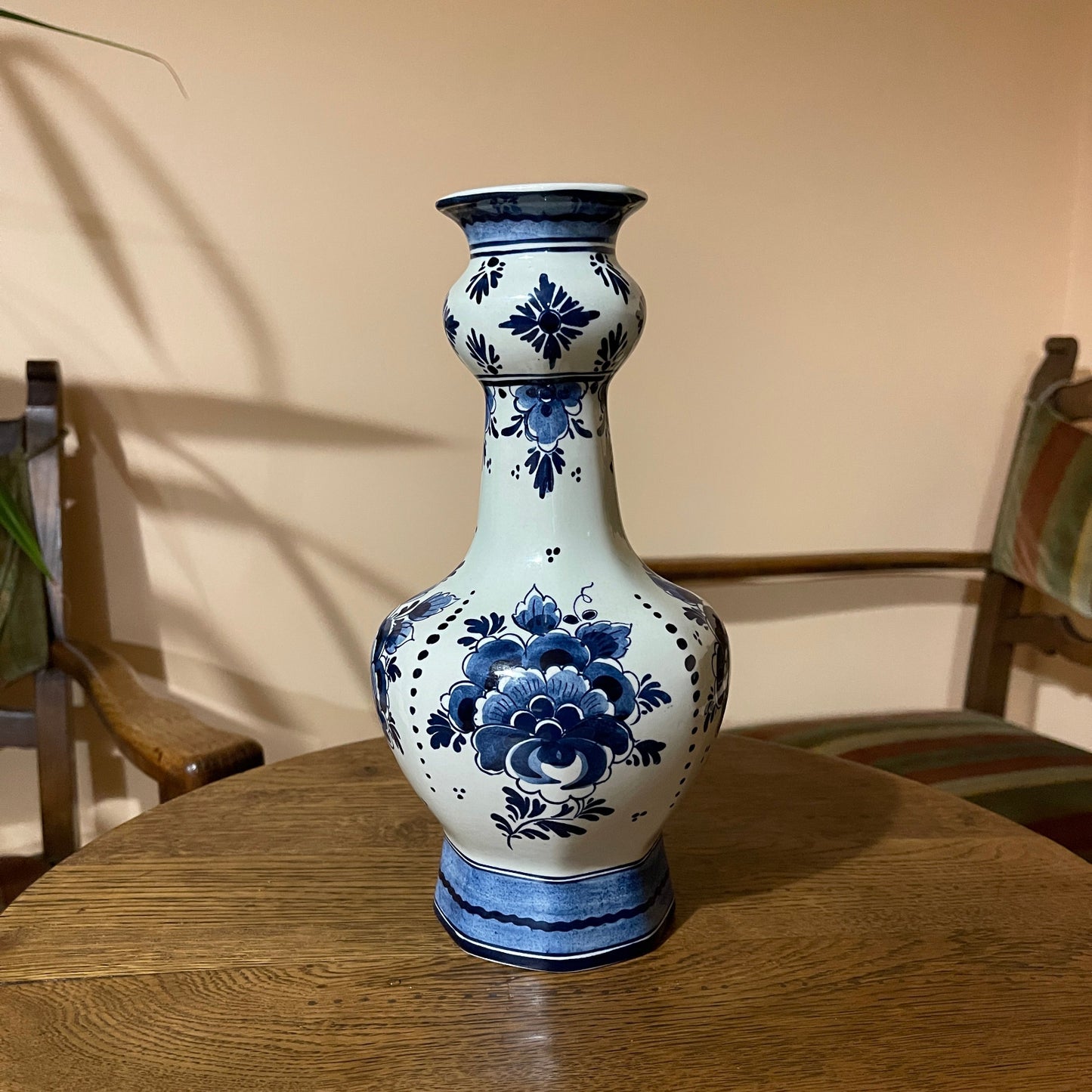 Blue and white floral-patterned vase on a wooden table with a neutral background