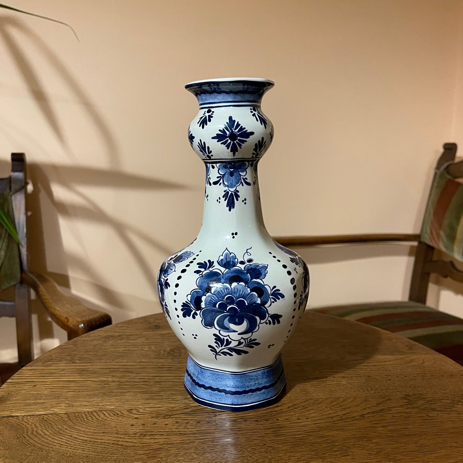 Blue and white floral-patterned vase on a wooden table with a neutral background