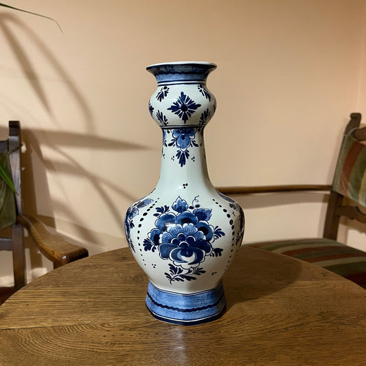 Blue and white floral-patterned vase on a wooden table with a neutral background
