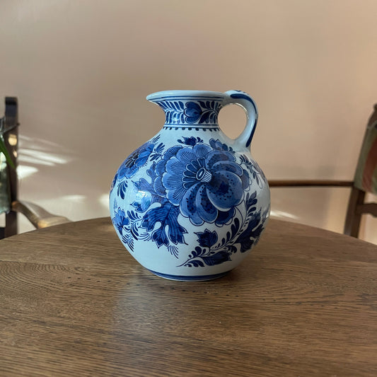 Blue and white floral-patterned ceramic pitcher on a wooden table