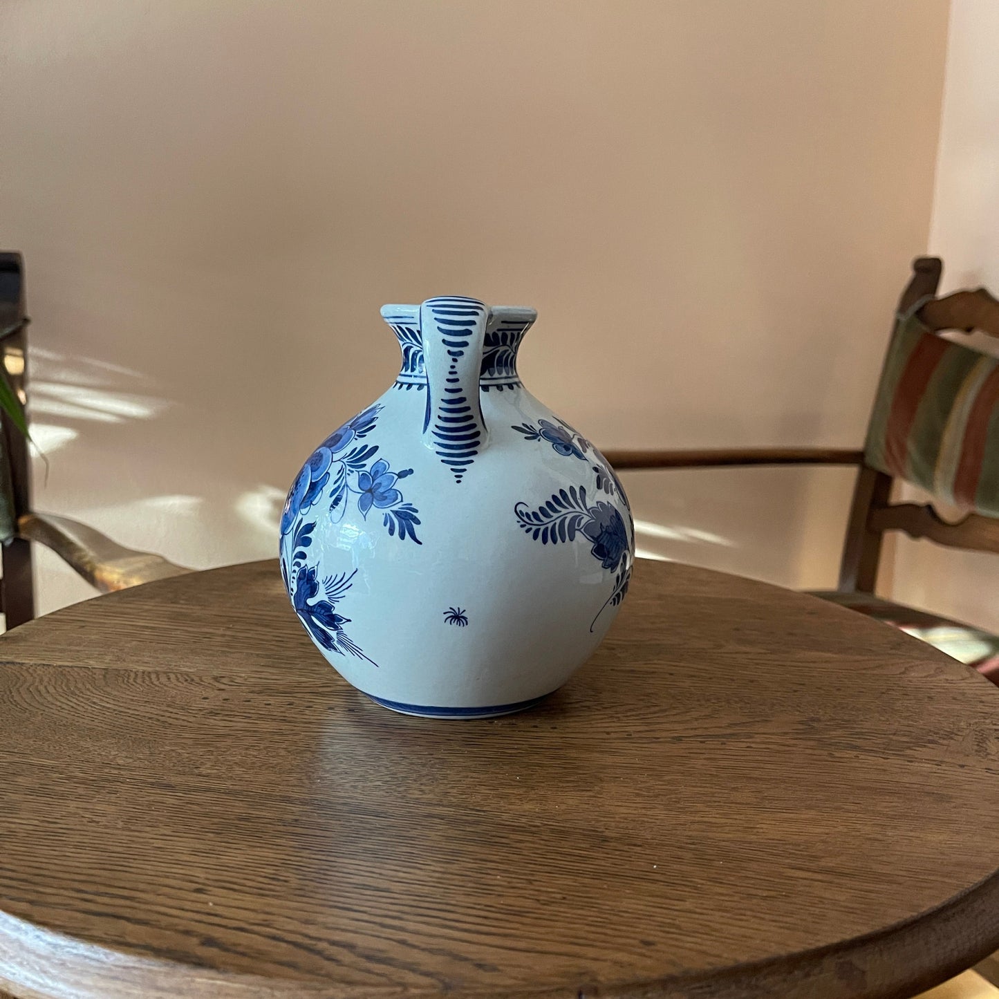 White vase with blue floral patterns on a wooden table
