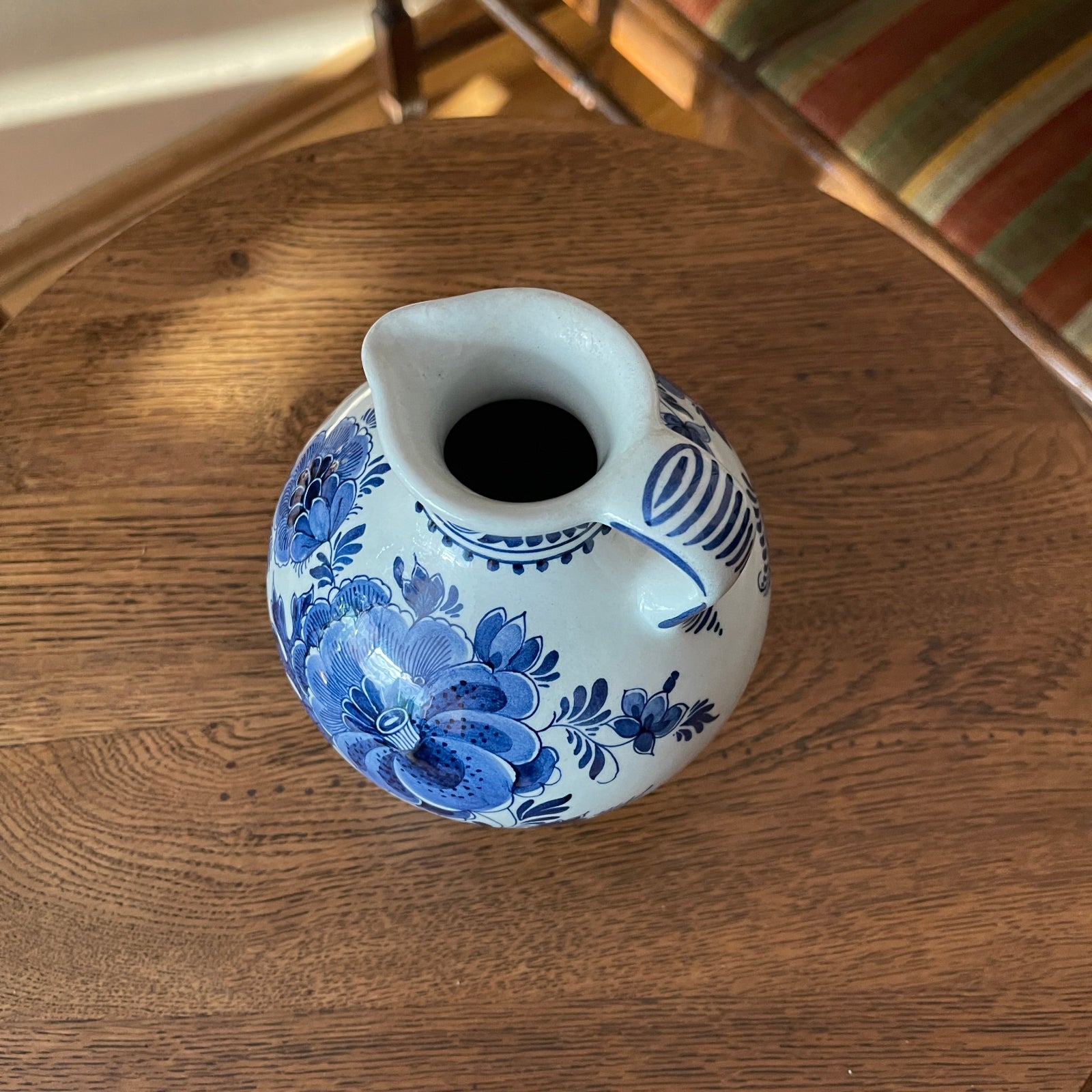 Blue and white ceramic pitcher on a wooden surface