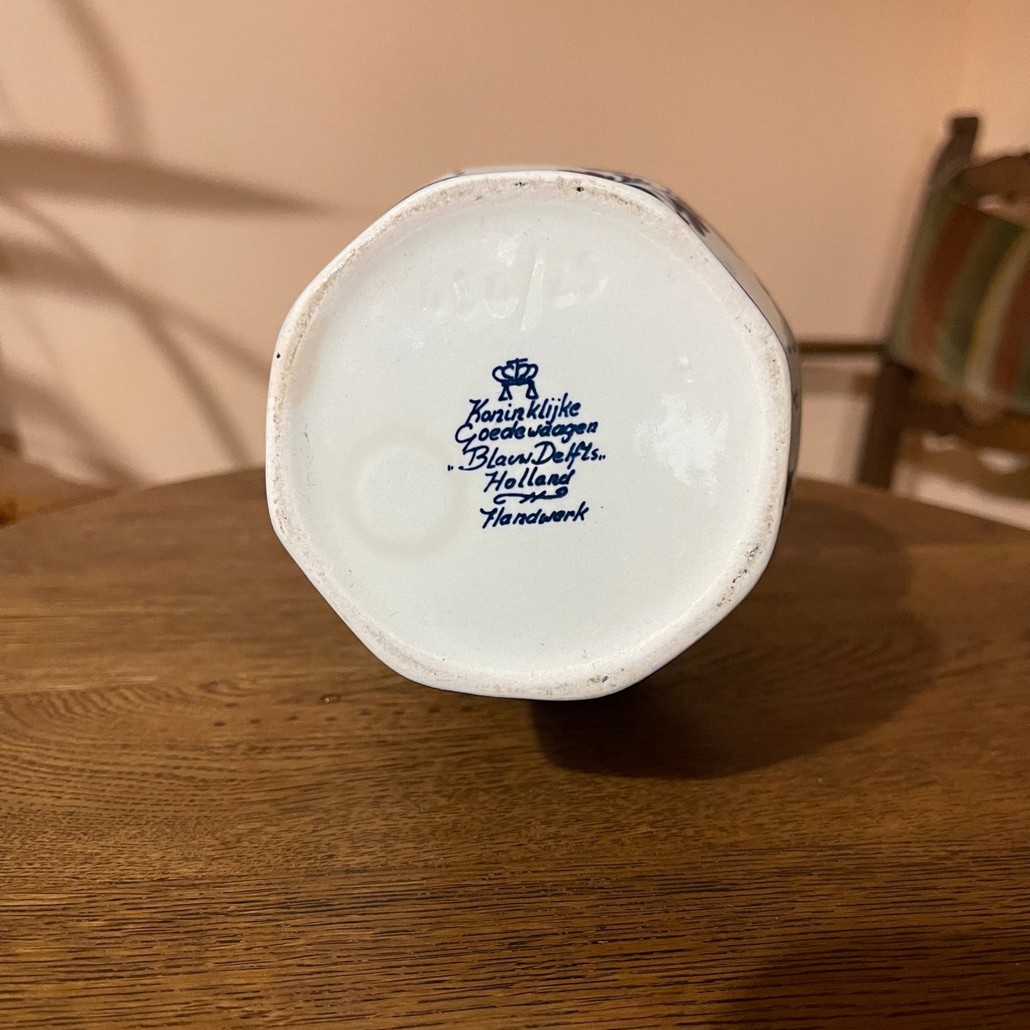 Ceramic vase with 'Koninklijke Czoeke & Van der Aa Delft Holland Handwerk' branding on a wooden surface.