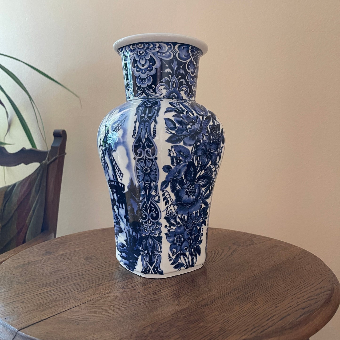 Blue and white floral-patterned vase on a wooden surface with a neutral background