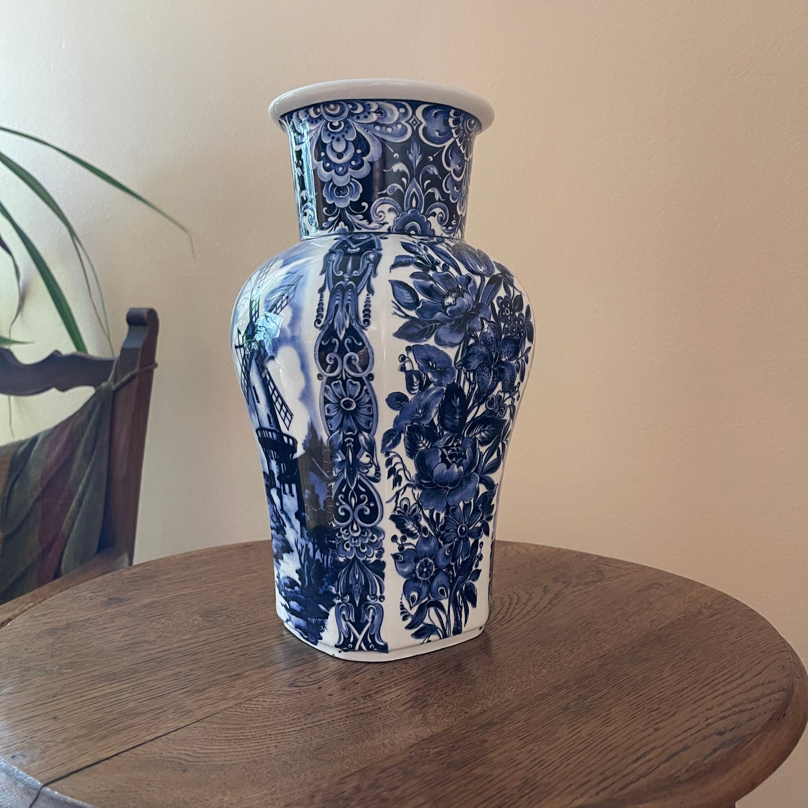 Blue and white floral-patterned vase on a wooden surface with a neutral background