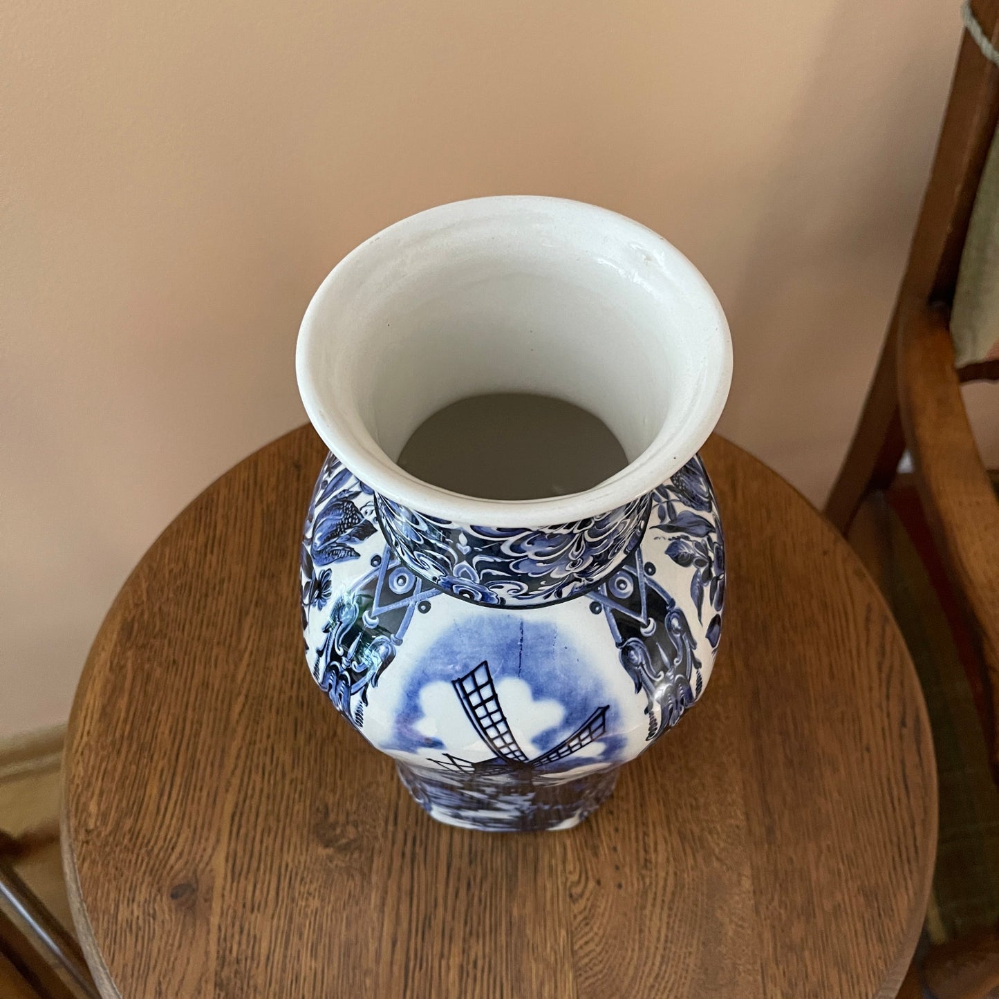 Blue and white ceramic vase on a wooden surface with a neutral background