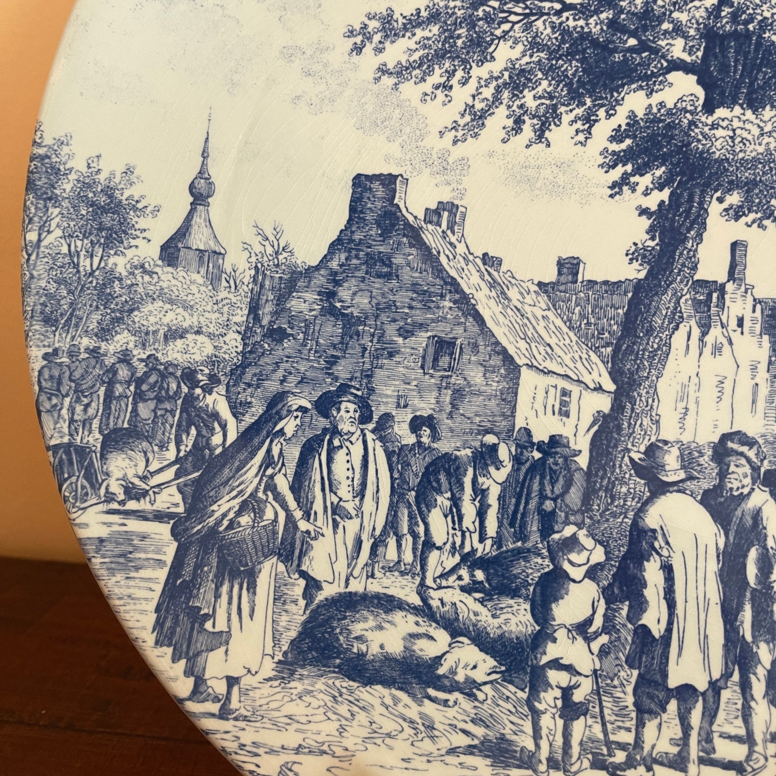 Vintage-style illustration of a village scene with people and buildings.
