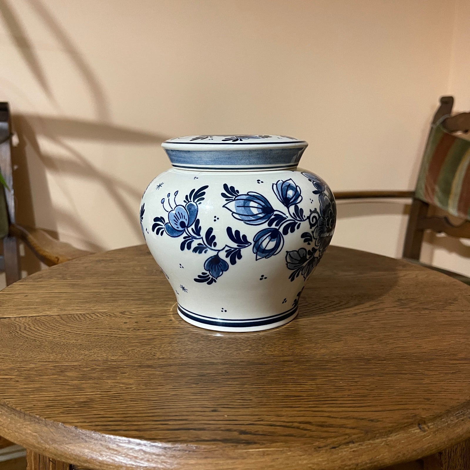 White ceramic vase with blue floral patterns on a wooden table