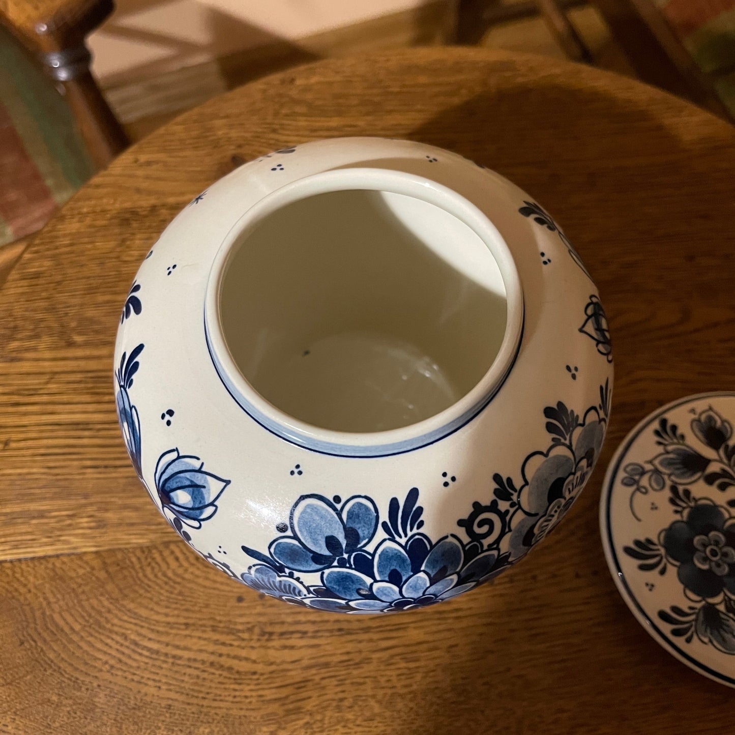 Blue and white ceramic jar with floral patterns on a wooden surface