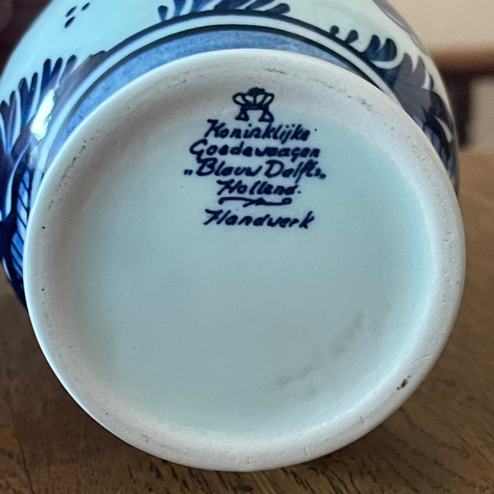 Close-up of a blue and white ceramic product with 'Koninklijke Czocha' branding on a wooden surface.