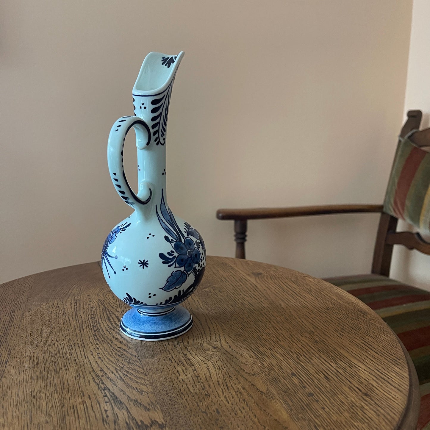 Ceramic pitcher with blue and white design on a wooden table
