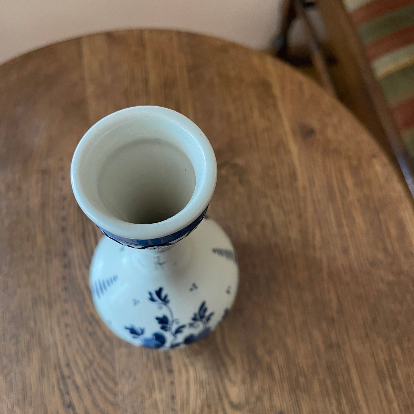 White vase with blue floral patterns on a wooden surface