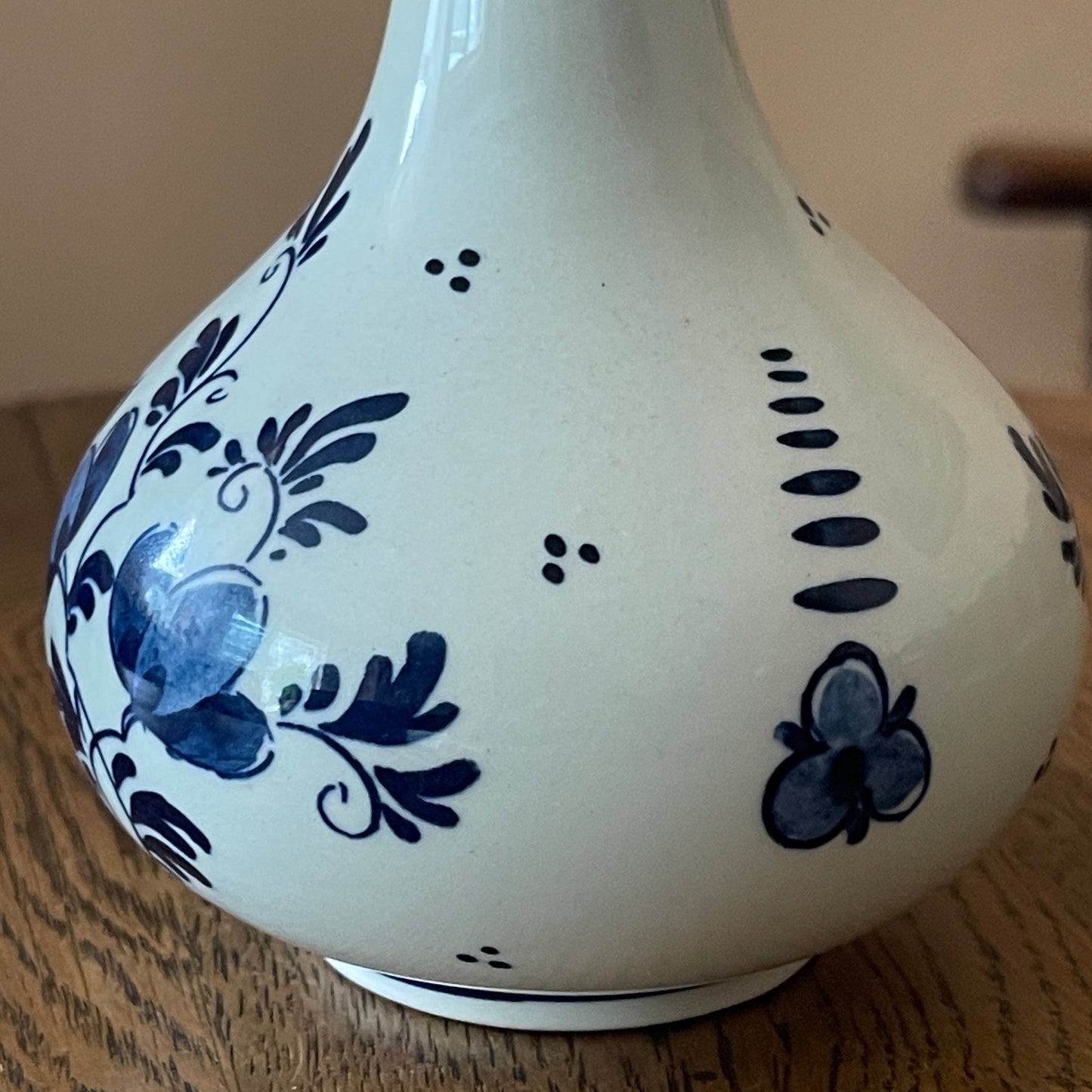 White ceramic vase with blue floral patterns on a wooden surface
