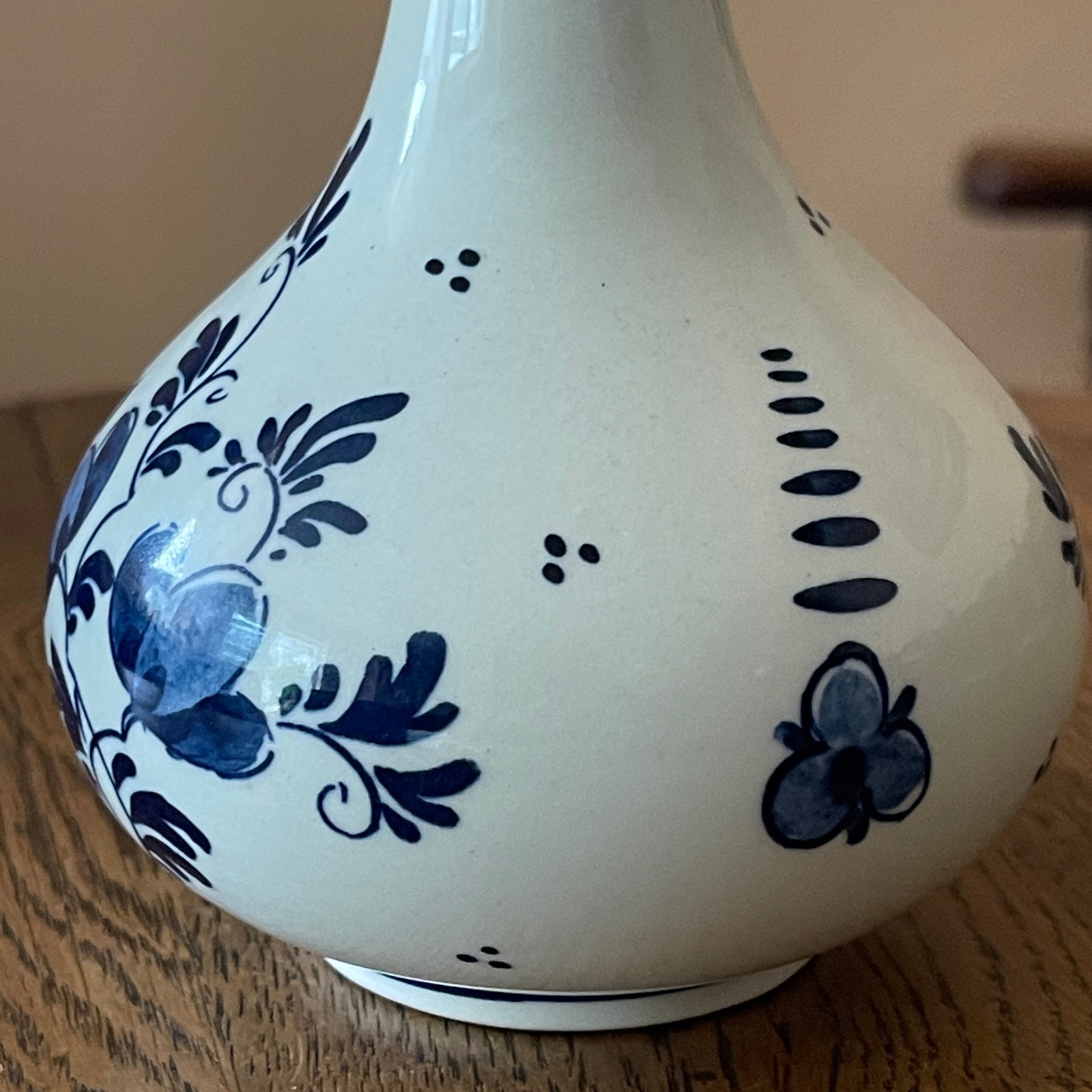 White ceramic vase with blue floral patterns on a wooden surface