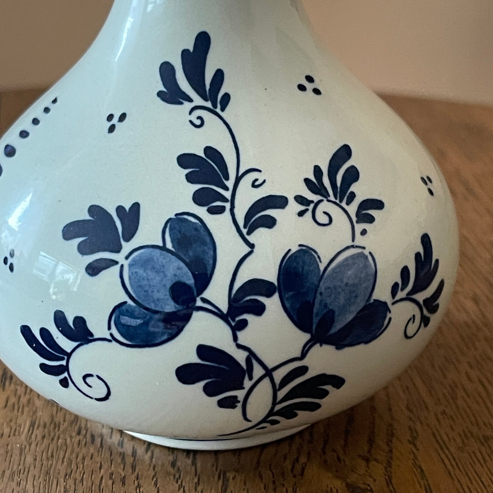 White ceramic vase with blue floral patterns on a wooden surface