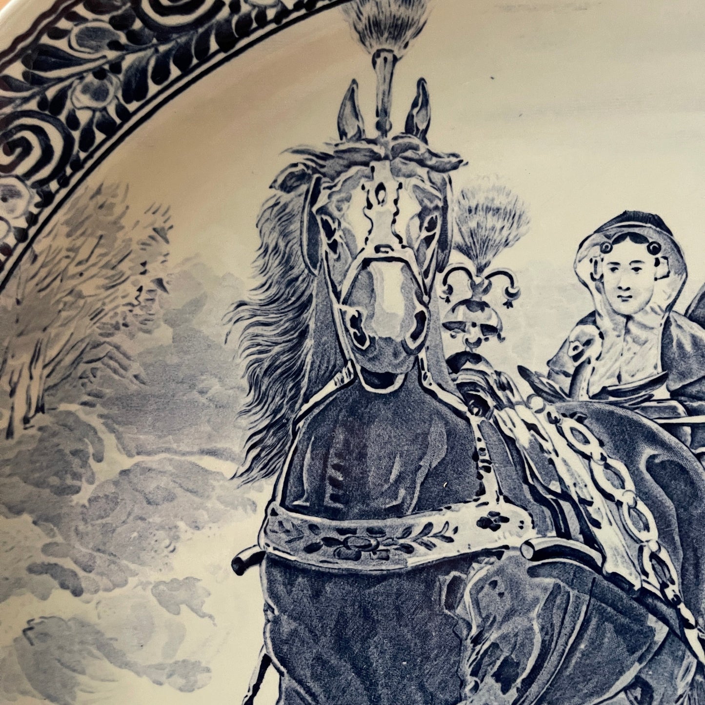 Decorative plate with a horse and rider design on a beige background