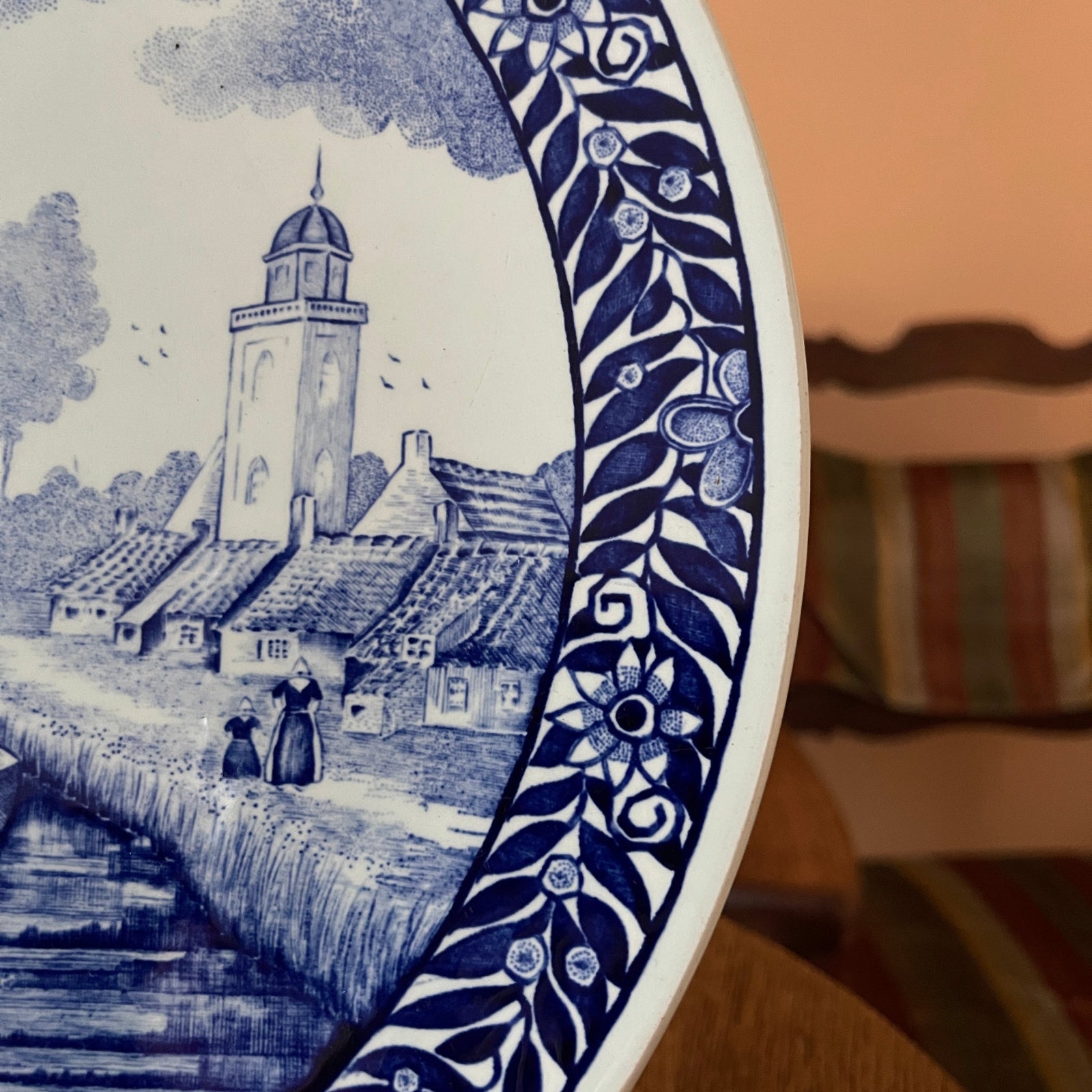 Dutch delftware plate with blue and white design of a tower and people by a river