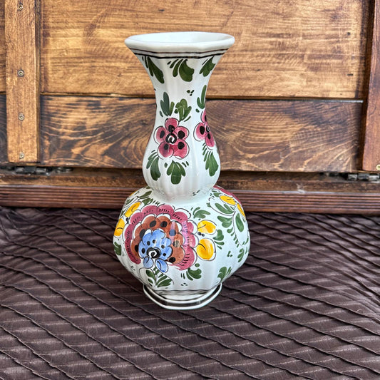 Decorative ceramic vase with floral patterns on a wooden surface