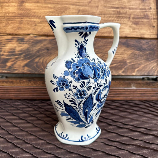 Ceramic pitcher with blue floral patterns on a wooden surface