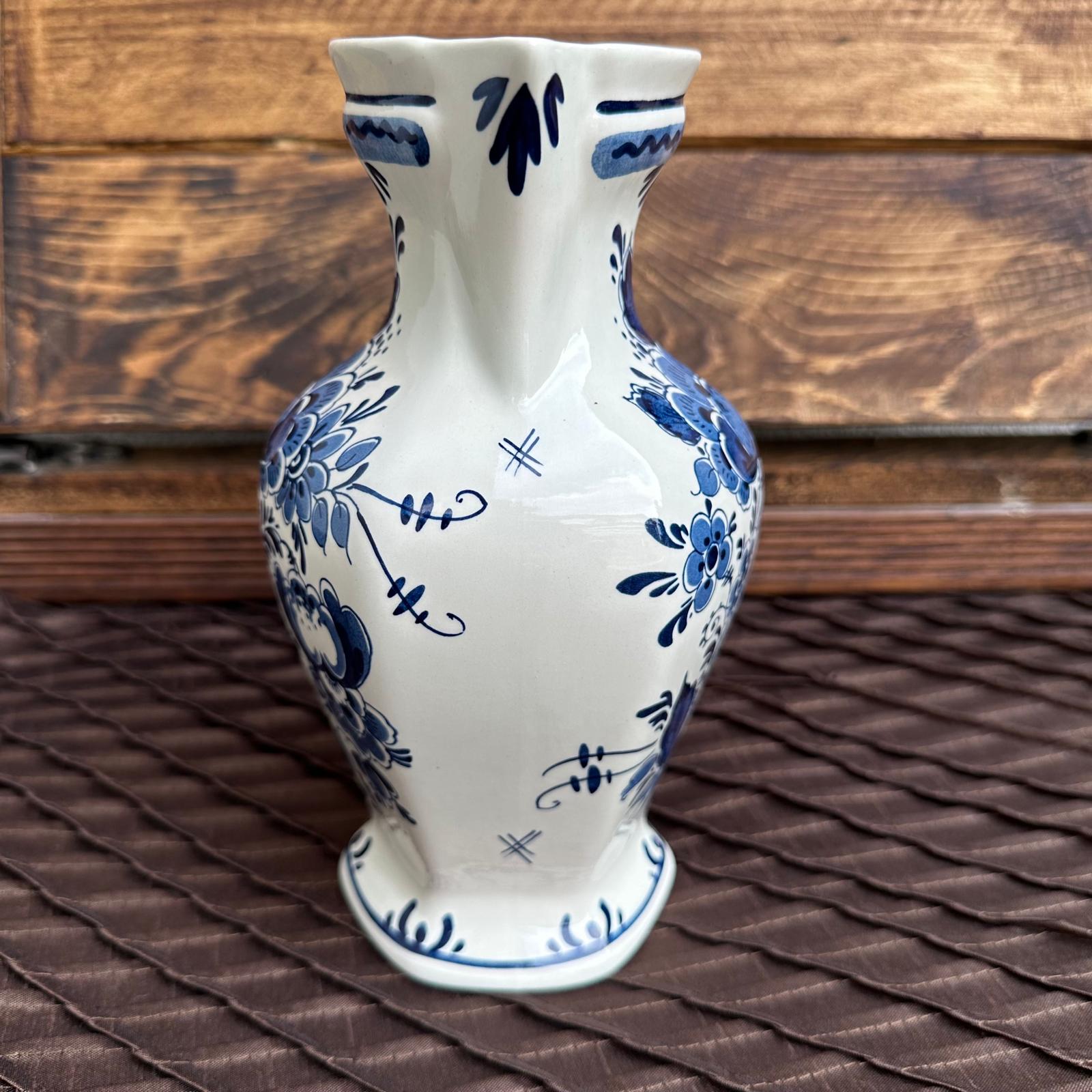 White ceramic vase with blue floral patterns on a wooden surface