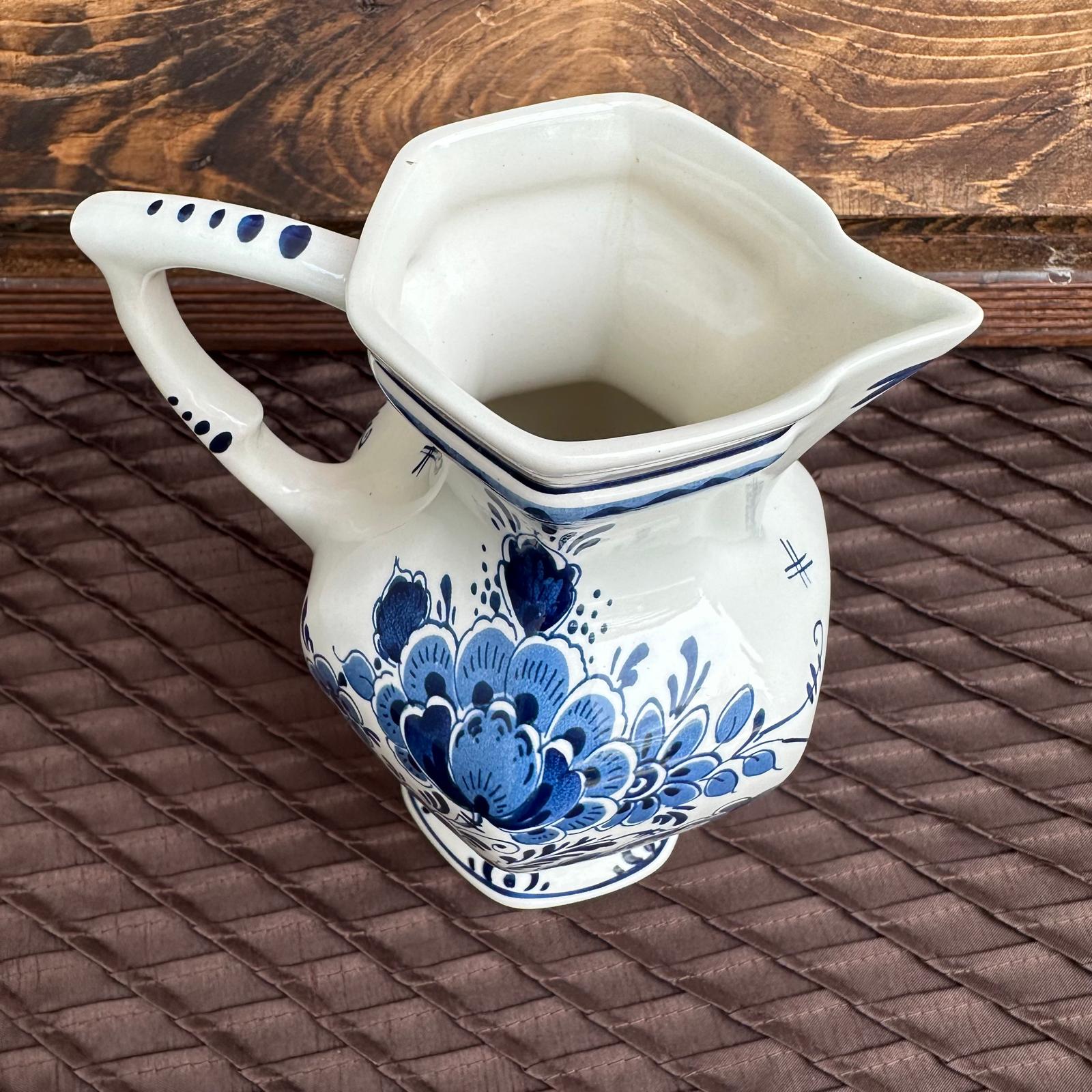 Ceramic pitcher with blue floral patterns on a textured surface
