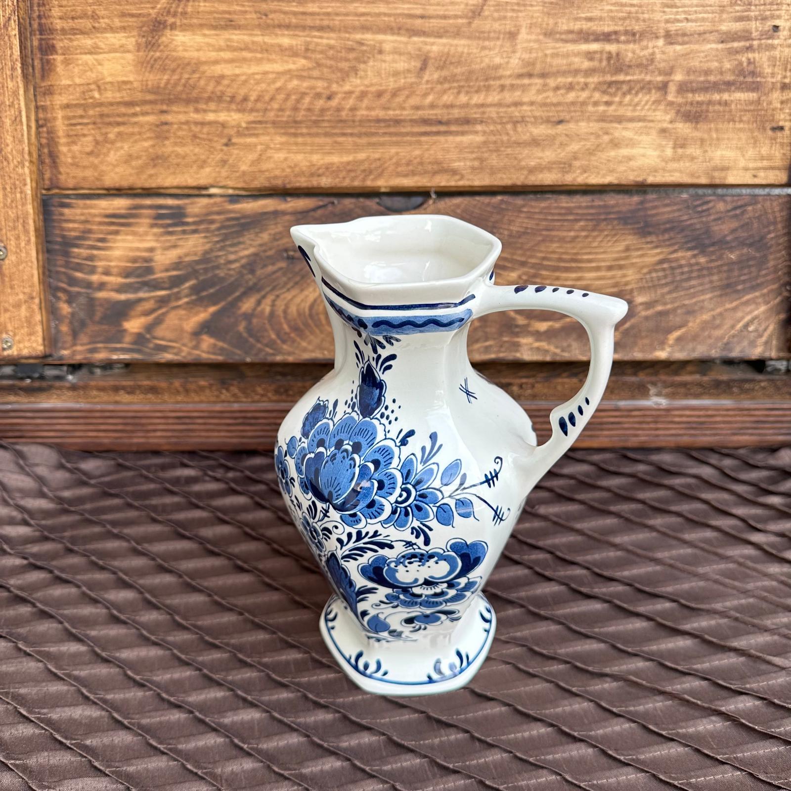 White ceramic pitcher with blue floral patterns on a wooden surface