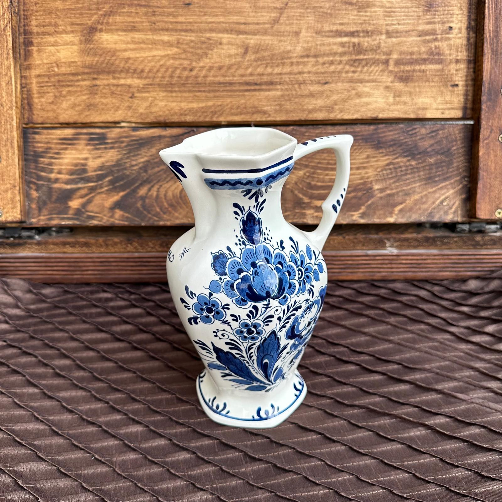 White ceramic vase with blue floral patterns on a wooden surface