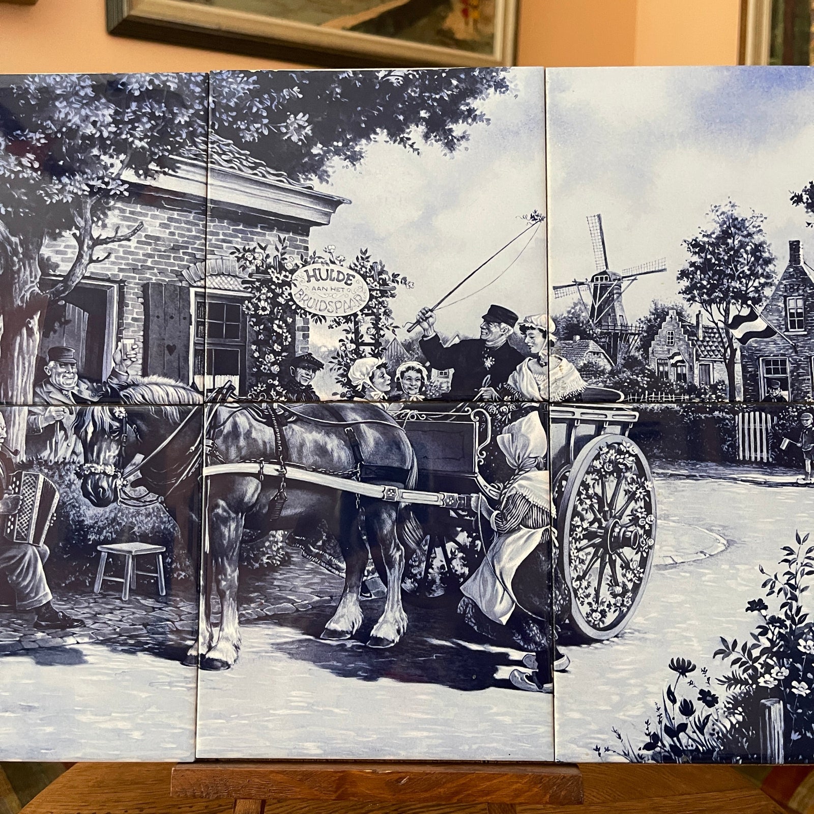 Black and white mural of a horse-drawn carriage scene with people and a windmill.