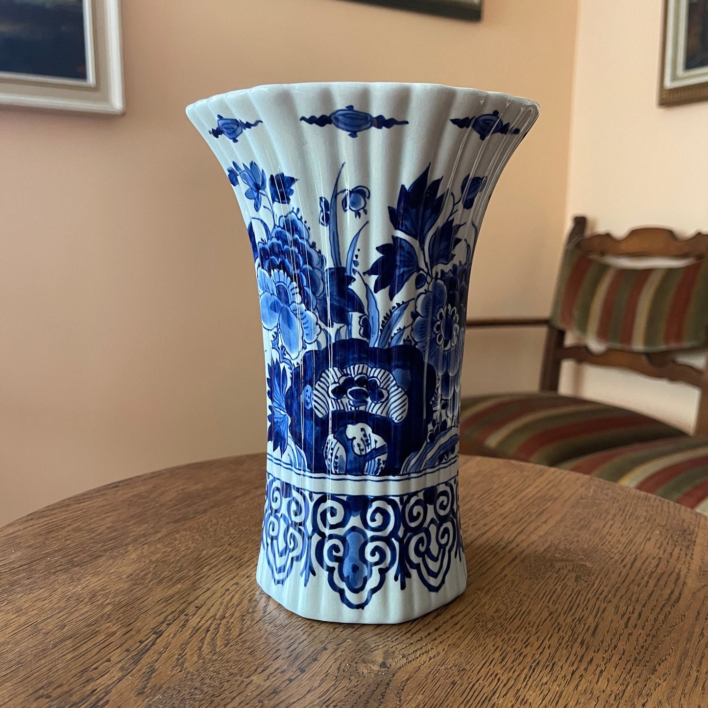 Blue and white floral-patterned vase on a wooden table with a blurred background