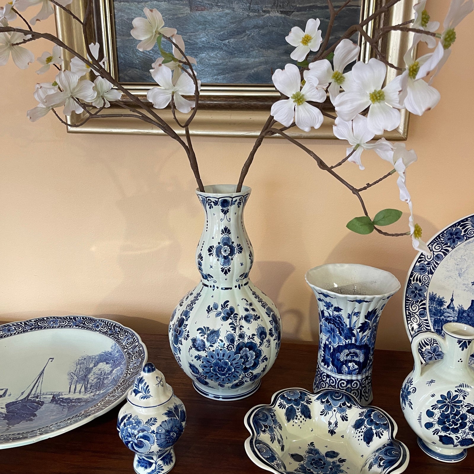 Collection of blue and white ceramic items including vases and a bowl on a wooden surface.